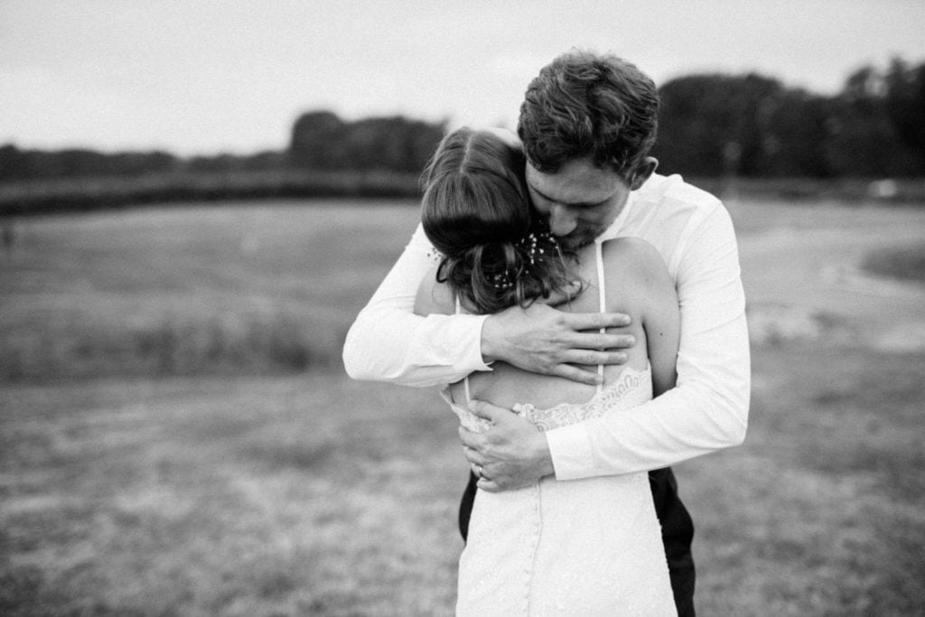 Bride and Groom sharing an emotion hug. Photo is in black and white