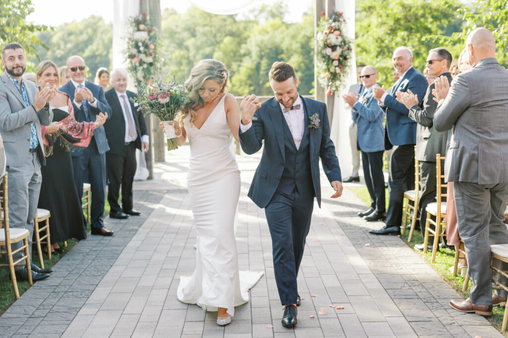 Bride & Groom leaving ceremony together at Stonewall estates by Niagara photographer