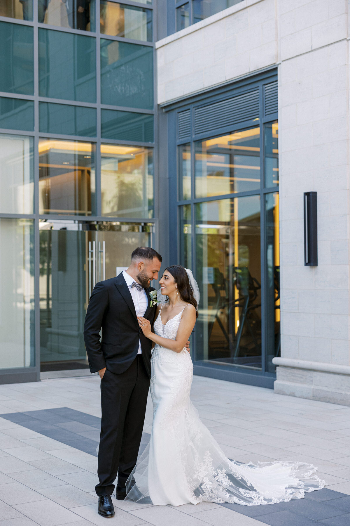 Bride & Groom At The Pearle Hotel For Outside Photos on Their wedding day as they look romantically at each other.
